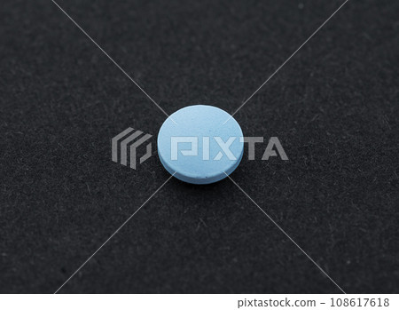 Single one blue pill, tablet or capsule on black background. Top view, flat lay and copy space. Minimalistic abstract medicine concept. 108617618