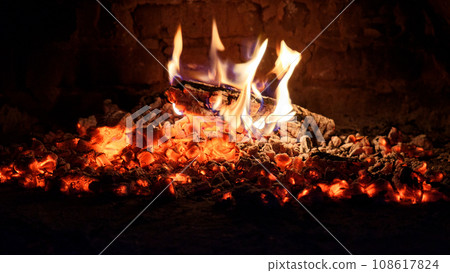 Logs of firewood burn out in the oven. Coals and flames in the fireplace. Logs of firewood burn out in the oven. Coals and flames in the fireplace. 108617824