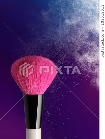 Burst of makeup powder with vibrant pink brush on colorful background 108618015
