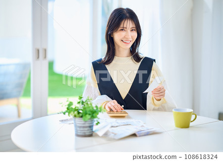 Housewife calculating on a calculator while looking at the receipt Housewife calculating on a calculator while looking at the receipt 108618324