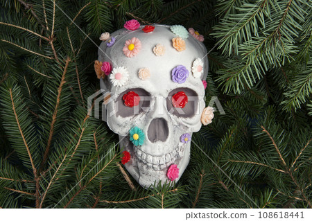 skull covered with multiple plastic flowers in different colors 108618441