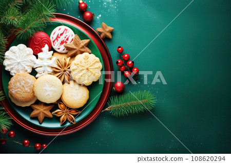 Christmas cookies candies and pine branches on green background Christmas cookies candies and pine branches on green background 108620294