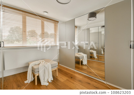 a modern bathroom with wood flooring and large mirrors on the wall, along with a white bathrobear a modern bathroom with wood flooring and large mirrors on the wall, along with a white bathrobear 108623203