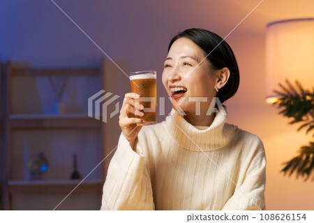 A woman drinking beer and relaxing A woman drinking beer and relaxing 108626154