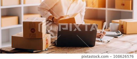 Business woman start up small business entrepreneur SME success .freelance woman working at home with Online Parcel delivery. SME and packaging deliveryconcept 108626576