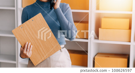 Business woman start up small business entrepreneur SME success .freelance woman working at home with Online Parcel delivery. SME and packaging deliveryconcept 108626597