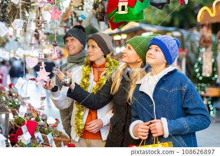 Friendly family chooses Christmas souvenirs and toys 108626897