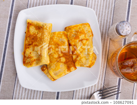 Delectable pancakes, featuring sweet fruit preserve filling 108627091
