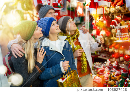 Winter holidays concept - happy mother, father and teenagers at christmas market 108627428