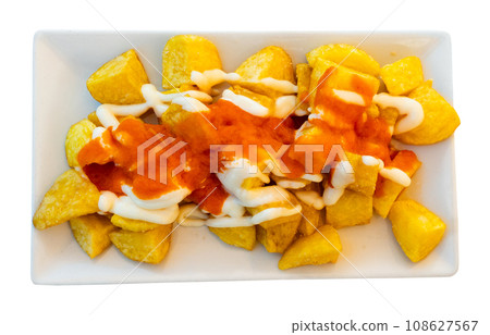 Spanish fried potatoes Patatas bravas served with cheese sauce Spanish fried potatoes Patatas bravas served with cheese sauce 108627567