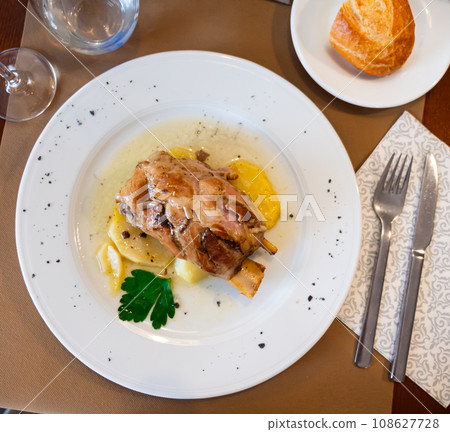 Pork knuckle baked in oven with boiled potatoes in white plate 108627728