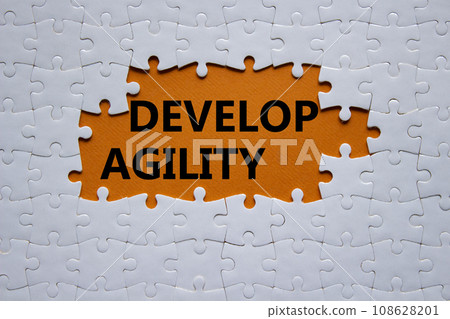 Develop agility symbol. Concept word Develop agility on white puzzle. Beautiful orange background. Business and Develop agility concept. Copy space Develop agility symbol. Concept word Develop agility on white puzzle. Beautiful orange background. Business and Develop agility concept. Copy space 108628201