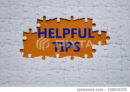 Helpful tips symbol. White puzzle with words Helpful tips. Beautiful orange background. Business and Helpful tips concept. Copy space. Helpful tips symbol. White puzzle with words Helpful tips. Beautiful orange background. Business and Helpful tips concept. Copy space. 108628203