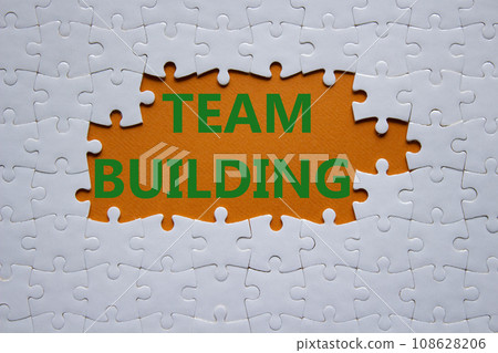 Team Building symbol. Concept word Team Building on white puzzle. Beautiful orange background. Business and Team Building concept. Copy space Team Building symbol. Concept word Team Building on white puzzle. Beautiful orange background. Business and Team Building concept. Copy space 108628206