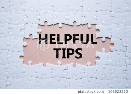 Helpful tips symbol. White puzzle with words Helpful tips. Beautiful pink background. Business and Helpful tips concept. Copy space. 108628210