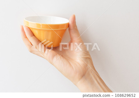 拿著一個小橙色盤子的手 拿著一個小橙色盤子的手 108629652