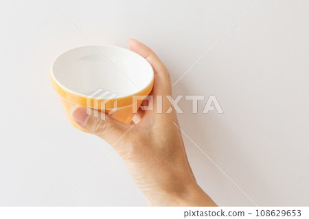 hand holding a small orange plate hand holding a small orange plate 108629653