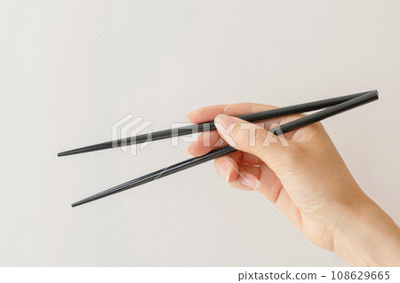 Hand with chopsticks 108629665