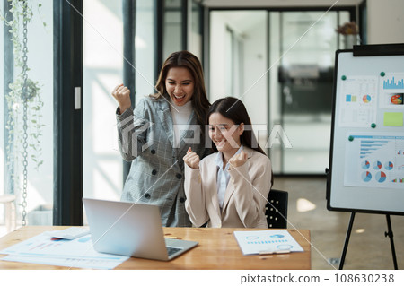 Financial analysts analyzing business reports on planned investment projects during corporate meeting discussions showcase successful teamwork with marketing plan, computers and calculators to work. 108630238