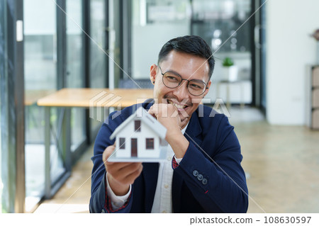 Guarantee, Mortgage, agreement, contract, Signing, Male client holding pen to reading agreement document to sign land loan with real estate agent or bank officer. Guarantee, Mortgage, agreement, contract, Signing, Male client holding pen to reading agreement document to sign land loan with real estate agent or bank officer. 108630597