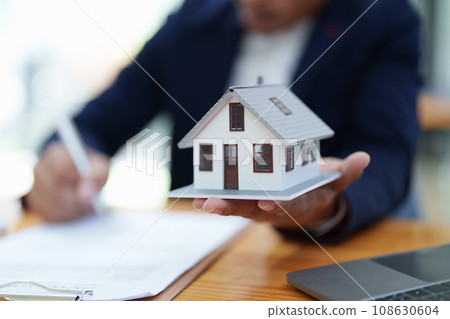Guarantee, Mortgage, agreement, contract, Signing, Male client holding pen to reading agreement document to sign land loan with real estate agent or bank officer. Guarantee, Mortgage, agreement, contract, Signing, Male client holding pen to reading agreement document to sign land loan with real estate agent or bank officer. 108630604