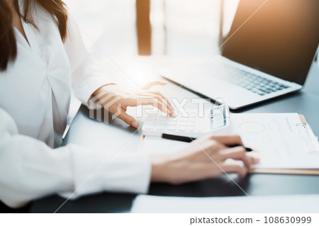 Accountants, Asian auditors are using calculators and computers to review annual tax budgets to submit information to the IRS 108630999