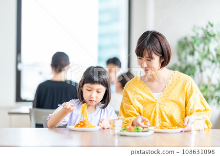 A family eating at a restaurant. A family eating at a restaurant. 108631098