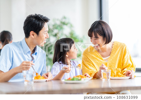 A family eating at a restaurant. A family eating at a restaurant. 108631099