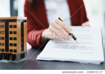 Guarantee, mortgage, agreement, contract, signed, real estate agent pointing to documents for customers to read the agreement before signing important documents. 108631117