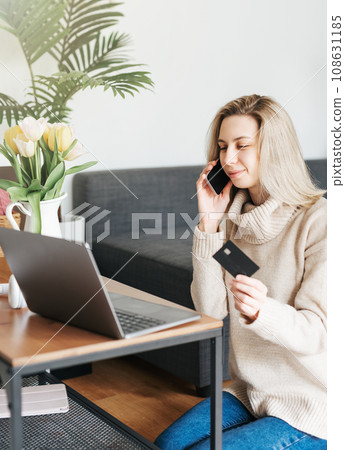 Young woman holding credit card and using laptop. Young woman holding credit card and using laptop. 108631185