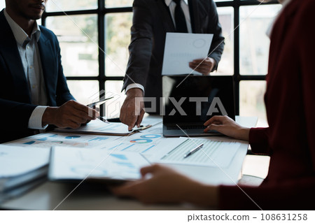 Team business adviser meeting to analyze and discuss the situation on the financial report n the meeting room with using documents, calculator, computer laptop in work Team business adviser meeting to analyze and discuss the situation on the financial report n the meeting room with using documents, calculator, computer laptop in work 108631258