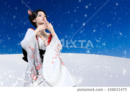 一位身穿和服、留著日式頭髮的迷人女子在雪景中手持扇子翩翩起舞。 一位身穿和服、留著日式頭髮的迷人女子在雪景中手持扇子翩翩起舞。 108631475