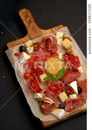 Meat Charcuterie Plate with Prosciutto crudo, Salami and Coppa Sausage. Black background. Top view. Meat Charcuterie Plate with Prosciutto crudo, Salami and Coppa Sausage. Black background. Top view. 108631509
