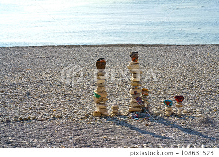 figures made of stones on the beach against the backdrop of the sea. A vertical figure made of stones stands against the backdrop of water. Inscriptions of gratitude on stones figures made of stones on the beach against the backdrop of the sea. A vertical figure made of stones stands against the backdrop of water. Inscriptions of gratitude on stones 108631523