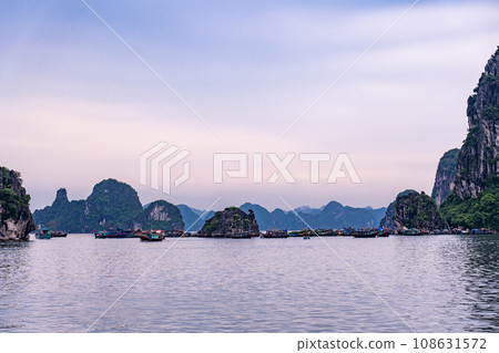 Strangely shaped rocks and fishing boats in Ha Long Bay, Vietnam Strangely shaped rocks and fishing boats in Ha Long Bay, Vietnam 108631572