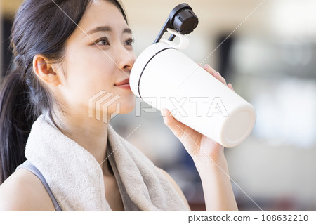 Young woman drinking protein after training at the gym 108632210