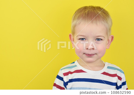 Happy smiling little boy on color background. Portrait of beautiful European boy two years old on a yellow background. Copy space for text. Happy smiling little boy on color background. Portrait of beautiful European boy two years old on a yellow background. Copy space for text. 108632590