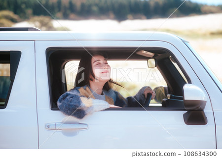 A woman driving in nature 108634300