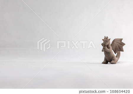 Cute unglazed ceramic dragon figurine 108634420