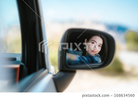 Woman checking back mirror 108634560