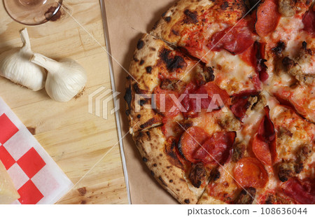 Fresh Pizza on Wooden Table at Restaurant Sliced and Ready to Eat Fresh Pizza on Wooden Table at Restaurant Sliced and Ready to Eat 108636044