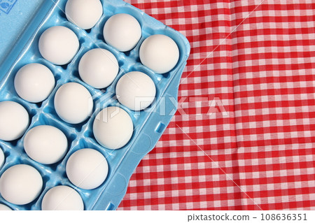 Carton of Eggs on Rustic Table With Checkered Table Cloth 108636351