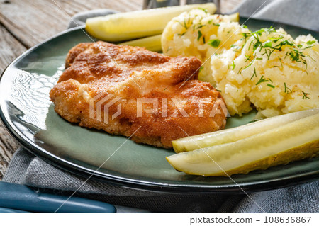 Pork chop served with mashed potatoes and pickled cucumber. Pork chop served with mashed potatoes and pickled cucumber. 108636867