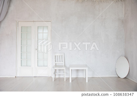 White Chair Coffee Table And Oval Mirror In Empty White Room Interior 108638347
