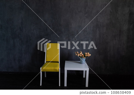 chair and coffee table with flowers in dark room interior chair and coffee table with flowers in dark room interior 108638409
