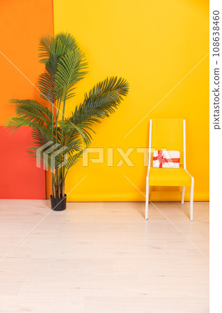 Vintage chair with gift in interior on yellow background Vintage chair with gift in interior on yellow background 108638460