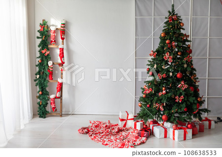 Christmas, New Year interior with red brick wall background, decorated fir tree with garlands and balls Christmas, New Year interior with red brick wall background, decorated fir tree with garlands and balls 108638533