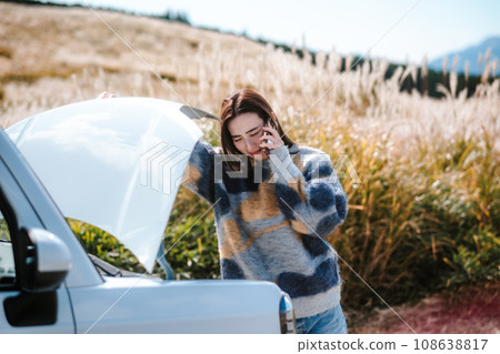 A woman is in trouble because her car broke down while driving. 108638817