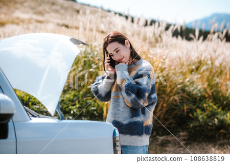 一名婦女因汽車在行駛時拋錨而陷入困境。 108638819