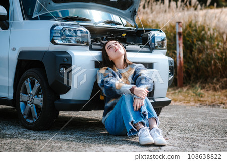 一名婦女因汽車在行駛時拋錨而陷入困境。 一名婦女因汽車在行駛時拋錨而陷入困境。 108638822